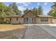 Charming single-story home boasts stone accents, solar panels, and a concrete driveway with decorative gravel walkway at 1240 W Voorhis Ave, Deland, FL 32720