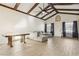 Bright living room includes a vaulted ceiling with exposed wooden beams, ceiling fan, and wood-look tile flooring at 1240 W Voorhis Ave, Deland, FL 32720