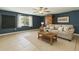 Comfortable living room featuring a neutral sofa, wood accents, and a large window with sheer curtains at 1240 W Voorhis Ave, Deland, FL 32720