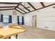 Open concept living space featuring wood-look tile floors, vaulted ceilings, and a glimpse into bathroom at 1240 W Voorhis Ave, Deland, FL 32720