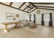 Bright living room with beamed ceilings, neutral decor, comfortable seating, and wood-look tile flooring at 1240 W Voorhis Ave, Deland, FL 32720