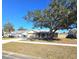 Landscaped yard with a one-story home and mature tree at 1387 Hensley Dr, Deland, FL 32724