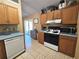 Galley kitchen with wood cabinets and stainless steel appliances at 1387 Hensley Dr, Deland, FL 32724
