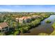A serene view of a condominium complex nestled among lush greenery along the still waters of a pond at 1401 S Palmetto Ave # 614, Daytona Beach, FL 32114