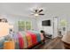 Bright bedroom with a ceiling fan, hardwood floors, and a wall-mounted television at 1401 S Palmetto Ave # 614, Daytona Beach, FL 32114