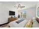 Staged bedroom featuring a ceiling fan, large window, dresser with TV, and neutral decor at 1401 S Palmetto Ave # 614, Daytona Beach, FL 32114