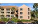 Three-story condo building with tan facade, balconies, palm trees, and convenient parking at 1401 S Palmetto Ave # 614, Daytona Beach, FL 32114