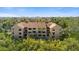 Exterior view of a multi-story condo surrounded by lush greenery at 1401 S Palmetto Ave # 614, Daytona Beach, FL 32114