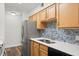 Well-lit kitchen with wood cabinets, stainless steel refrigerator, and blue tiled backsplash at 1401 S Palmetto Ave # 614, Daytona Beach, FL 32114
