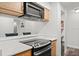 Well-lit kitchen featuring a black glass cooktop, wood cabinets, and white countertop at 1401 S Palmetto Ave # 614, Daytona Beach, FL 32114