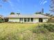 Home's rear elevation showcasing a large grassy yard at 1412 Oak Forest Dr, Ormond Beach, FL 32174