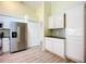 White kitchen cabinets, stainless steel appliances, and wood flooring at 1412 Oak Forest Dr, Ormond Beach, FL 32174