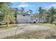White house with attached garage and long driveway at 1450 Alden St, Deland, FL 32720