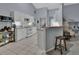 Bright eat-in kitchen with white cabinets, tile floor, and peninsula breakfast bar at 1450 Alden St, Deland, FL 32720