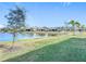 View of a lake and other houses from a backyard with grass at 1627 Delphi Way, New Smyrna Beach, FL 32168