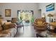 Living room with leather furniture, hardwood floors, and sliding glass doors leading to a view of the pool and waterfall at 19343 Moorgate St, Orlando, FL 32833