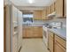 Kitchen with light wood cabinets, white appliances, and blue countertop at 2 Villa Villar Ct # 02, Deland, FL 32724