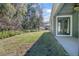 Landscaped backyard with a grassy area and trees at 204 Wellington Woods Ave, Deland, FL 32724
