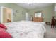 Main bedroom with floral bedding and access to the ensuite bathroom at 204 Wellington Woods Ave, Deland, FL 32724