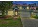 Charming two-story home with a brick driveway, two-car garage, landscaped yard and covered front entry at 204 Wellington Woods Ave, Deland, FL 32724