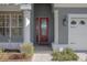 Red front door entrance with white columns and brick walkway at 204 Wellington Woods Ave, Deland, FL 32724