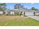White house with solar panels, landscaped yard, and a two-car garage at 216 Hickory Ave, Orange City, FL 32763