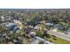 High-angle view showcasing a residential area with a red house, tree-lined streets, and surrounding houses at 229 S Adams St, Daytona Beach, FL 32114