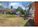 Spacious backyard with lush green grass, a storage shed, and mature trees, perfect for outdoor activities at 229 S Adams St, Daytona Beach, FL 32114
