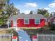 Red brick house with white picket fence and landscaped yard at 229 S Adams St, Daytona Beach, FL 32114