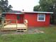 Cozy single-story home boasting a vibrant red exterior and a newly constructed wooden deck at 229 S Adams St, Daytona Beach, FL 32114