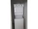 Picture of a white, stacked washer and dryer inside of a laundry room with an open door at 229 S Adams St, Daytona Beach, FL 32114