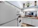 White kitchen cabinets, appliances, and granite countertop at 245 Terrace Hill Blvd # 1E, Debary, FL 32713