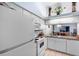White kitchen cabinets, appliances, and granite countertop at 245 Terrace Hill Blvd # 1E, Debary, FL 32713