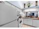 White kitchen cabinets, appliances, and granite countertop at 245 Terrace Hill Blvd # 1E, Debary, FL 32713