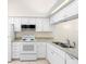 Well-lit kitchen featuring white cabinets, modern appliances, and ample counter space at 245 Terrace Hill Blvd # 1E, Debary, FL 32713