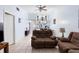 Bright living room with brown reclining sofas, tile floors, and a view into the kitchen at 245 Terrace Hill Blvd # 1E, Debary, FL 32713