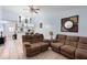 Bright living room with brown reclining sofas, tile floors, and a view into the kitchen at 245 Terrace Hill Blvd # 1E, Debary, FL 32713