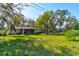 Large backyard with lush green grass and mature trees at 2608 Treehaven Dr, Deltona, FL 32738
