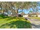 House exterior featuring a large oak tree and driveway at 2608 Treehaven Dr, Deltona, FL 32738