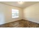 Simple bedroom with hardwood floors and a large window at 2709 Queen Palm Dr, Edgewater, FL 32141