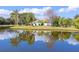 Scenic home exterior view with lush palm trees reflecting in the tranquil water at 2758 Turnbull Cove Dr, New Smyrna Beach, FL 32168