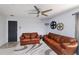 Gathering room featuring brown leather sofas, ceiling fan, and decorative wall art at 2758 Turnbull Cove Dr, New Smyrna Beach, FL 32168