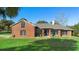 Brick home with a lush lawn and palm trees at 3057 Pinelock Dr, Deland, FL 32724