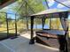 Covered patio featuring a hot tub and gazebo overlooking the lawn and pond view at 3169 Connemara Dr, Ormond Beach, FL 32174