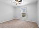 Bright bedroom with neutral walls and carpet, featuring a window with blinds and ceiling fan at 337 Orange Ave, Orange City, FL 32763
