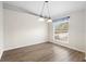 Simple dining room with light walls, wood-look floors, and a window with blinds at 337 Orange Ave, Orange City, FL 32763