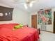 Cozy bedroom with a red comforter, built-in closet and ceiling fan at 347 Castlewood Ln, New Smyrna Beach, FL 32168
