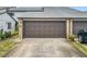 Attached garage with brown overhead door and stone facade at 347 Castlewood Ln, New Smyrna Beach, FL 32168