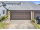 Attached garage with brown overhead door and stone facade at 347 Castlewood Ln, New Smyrna Beach, FL 32168