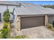 Attached garage with brown overhead door and stone facade at 347 Castlewood Ln, New Smyrna Beach, FL 32168